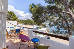 a balcony with chairs and tables and a view of the water at Ancla 1 in Port d'Andratx