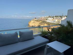 a couch sitting on a balcony overlooking the ocean at Bela Vista Suites in Carvoeiro