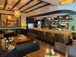 a restaurant with tables and chairs and a bar at Haus Waldesruh in Nettetal