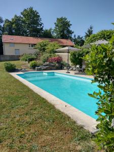 a swimming pool in the yard of a house at Gîtes de beaux rêves, Glycine in Uxeau