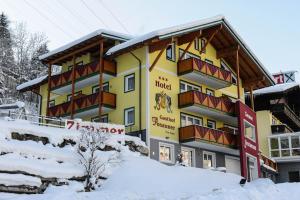 un edificio de hotel con nieve delante en Hotel Posauner, en Sankt Veit im Pongau