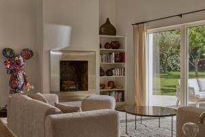 a living room with chairs and a table and a fireplace at Château de la Gaude in Aix-en-Provence