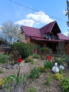 a house with a red roof and a garden at Затишок Карпат in Prelyuchka