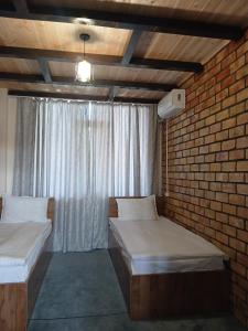 a room with two beds and a brick wall at Мурас хостел in Var-Kyshtak +10 photos