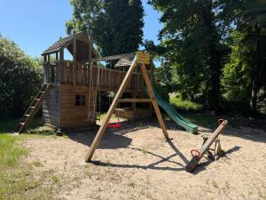 a wooden playground with a slide in the sand at Haus Waldesruh in Nettetal
