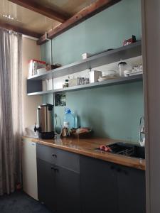 a kitchen with gray cabinets and a counter top at Мурас хостел in Var-Kyshtak