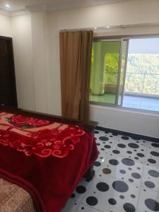 a bedroom with a bed and a large window at Koh E Sukoon Apartments in Patriata