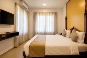 a bedroom with a large bed and a television at Bungalow Seven Mount Abu in Mount Ābu +99 photos