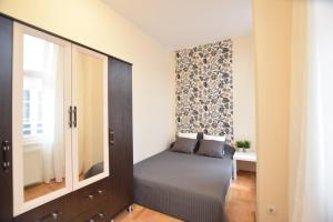 ブダペストにあるBudget Apartment by Hi5 - Fehérhajóのベッドルーム1室(ベッド1台付)、壁に鏡が備わります。