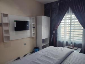 a bedroom with a bed and a tv and a window at Regent Hotels and Suites in Oshogbo +10 photos