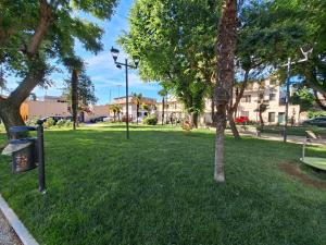 a park with a tree and a trash can in the grass at Casa Sant'Antonio in Orosei
