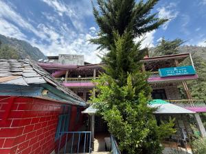 a palm tree in front of a building at Pine View By Wonderhill in Manīkaran
