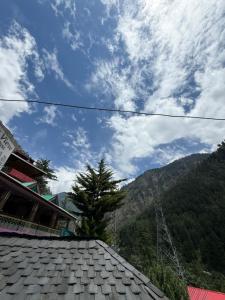 a view of a roof of a building and a mountain at Pine View By Wonderhill in Manīkaran