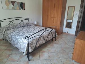 a bedroom with a bed and a tiled floor at Casa Sant'Antonio in Orosei