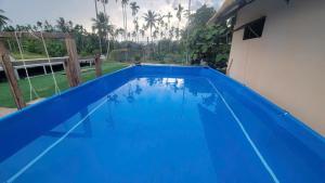 a large blue swimming pool in a house at BângGlamping in Hue