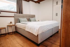 a large bed in a room with a window at Longaview in Weisspriach