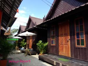 a building with wooden doors and an umbrella at KTT Resort Sukhothai & Motorbikes for rent & bicycles for rent in Sukhothai