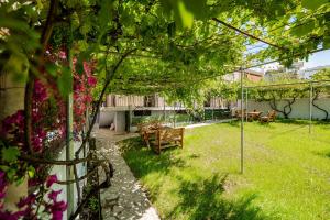 a garden with a table and chairs and flowers at Kalpazo Rental Kaya Stays in Golem