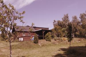 a house in the middle of a field with trees at Chaloupka Bečov in Blatno