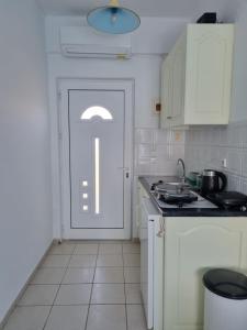 a kitchen with a white door and a stove at Calypso Studios in Amoudi +54 photos