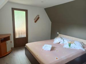 a bedroom with a bed with two towels on it at Pastravaria Romani in Horezu