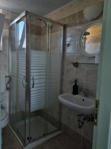 a bathroom with a shower and a sink at Calypso Studios in Amoudi