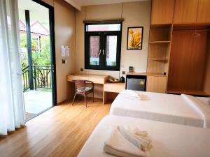 a hotel room with two beds and a desk and a window at T&T Bungalow in Ban Khouaphan +26 photos