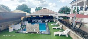 an outdoor patio with a pool and tables and chairs at Lazeto Hotel and Resorts in Zongon Daji