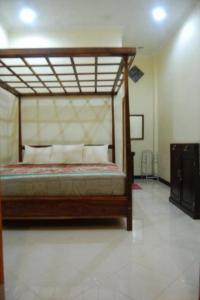 - une chambre avec un lit en bois dans l'établissement Aditya Homestay, à Munduk