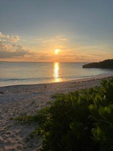 a sunset on a beach with the ocean at カリマタテラス宮古島 in Miyako-jima