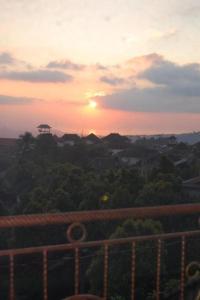 a sunset with the sun setting over a city at Aditya Homestay in Munduk