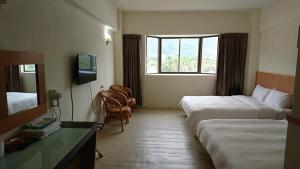 台東市的住宿－金樽大飯店，酒店客房设有两张床和窗户。