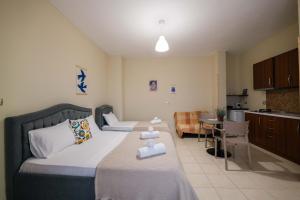 a bedroom with a bed and a kitchen with a table at Kalpazo Rental Kaya Stays in Golem