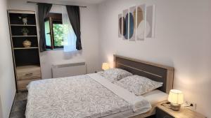 a bedroom with a bed with a white comforter at Holiday house Bliss in Kumrovec