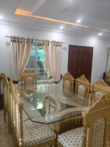 a dining room with a glass table and chairs at Koh E Sukoon Apartments in Patriata +3 photos