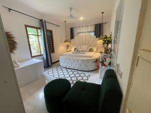 a living room with a tub and a bedroom at Malaika white house in Kiwengwa