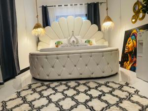 a white bed in a room with a rug at Malaika white house in Kiwengwa +1 photo