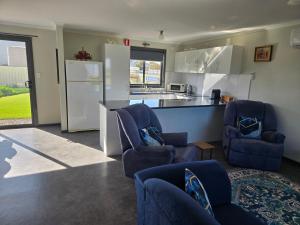 a kitchen with blue chairs and a counter with a refrigerator at Wudinna Farm View in Wudinna