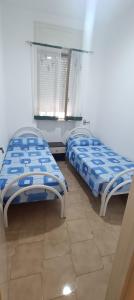 two beds sitting next to each other in a room at Villa Antonietta in Torre Lapillo