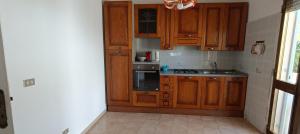 a kitchen with wooden cabinets and a stove top oven at Villa Antonietta in Torre Lapillo