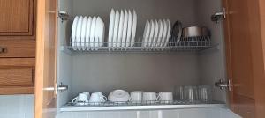 a cupboard filled with white dishes and plates at Villa Antonietta in Torre Lapillo