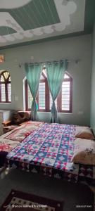a bedroom with a large bed with blue curtains at Rawat Homestay in Rishīkesh