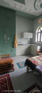 a room with a kitchen and a bed in it at Rawat Homestay in Rishīkesh