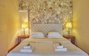 a bedroom with a large bed with two towels at Villa Helios Corfu Kassiopi in Kassiopi +24 photos