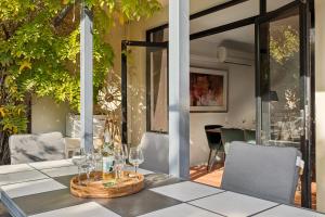 a table with wine glasses on top of it at Group stays for Friends Families Weddings and Events Walkable to Fremantle and attractions Super Spacious with garden and courtyard and balcony and parking for 2 cars Sleeps 6 3BD 3BR in Fremantle
