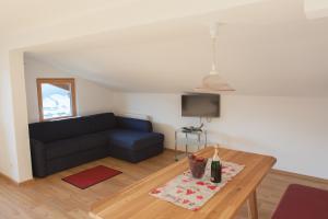 ein Wohnzimmer mit einem blauen Sofa und einem Tisch in der Unterkunft Hohe Tauernblick in Mittersill