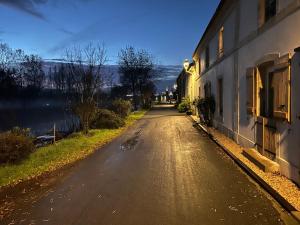 an empty street next to a building and a river at Chambre 1 bord de rivière in Damvix