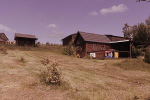 a group of houses on a hill in a field at Chaloupka Bečov in Blatno