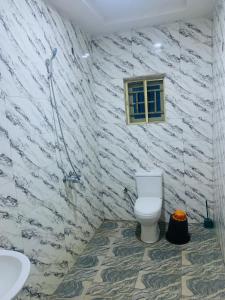 a bathroom with a toilet and a sink at Lazeto Hotel and Resorts in Zongon Daji +19 photos