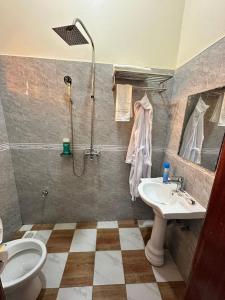 a bathroom with a shower and a sink and a toilet at GRACE ViLLA in Kitende